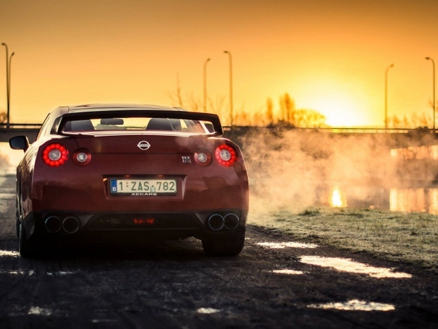 Красный Nissan у реки на рассвете