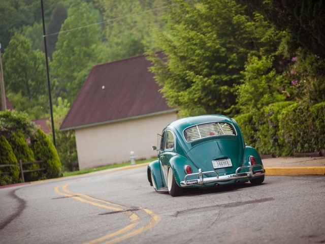 Зеленый Volkswagen Beetle на дороге