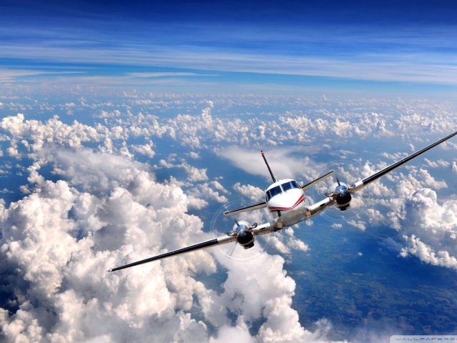 Частный самолет летит над облаками