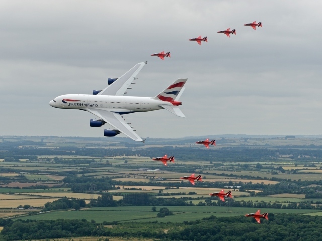 Airbus A380 в сопровождении красных истребителей