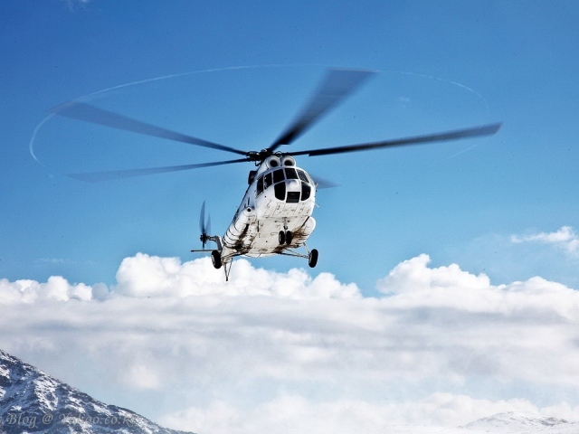 Вертолет на фоне облаков в горах