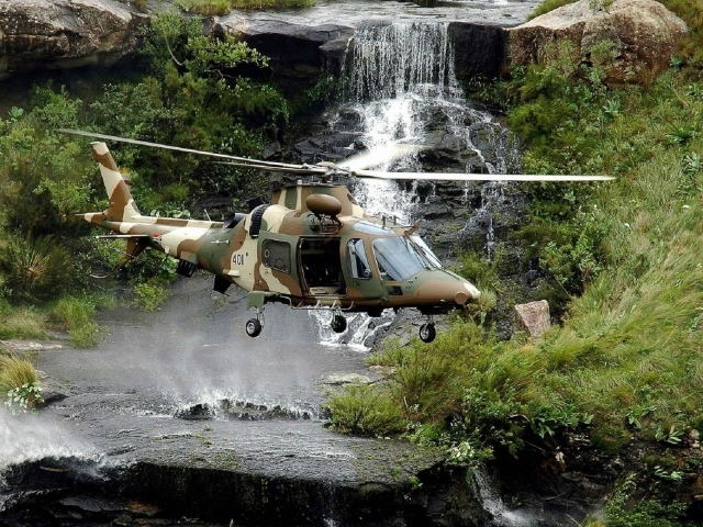 Военный вертолет над водопадом