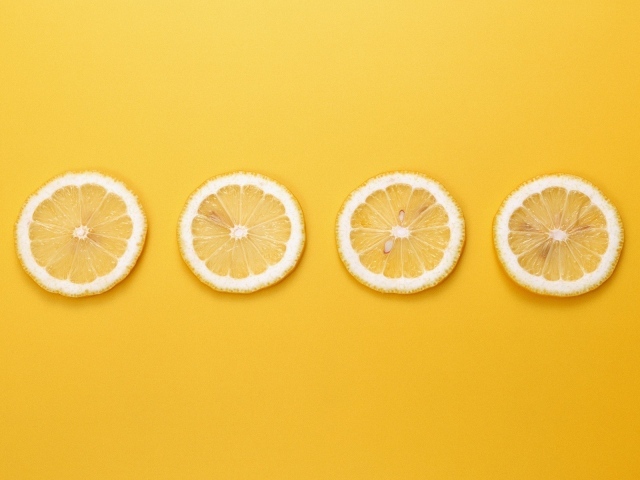 Кружки лимона, желтый фон