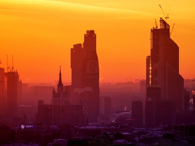 Стройка небоскребов на фоне оранжевого неба