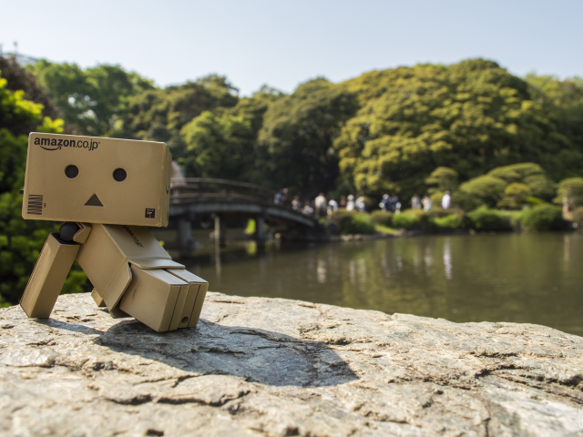 Картонный человечек на камне в саду