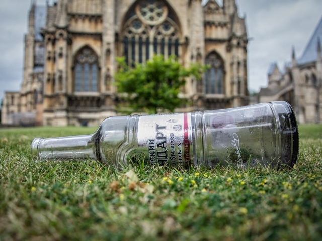 Пустая бутылка на газоне перед храмом