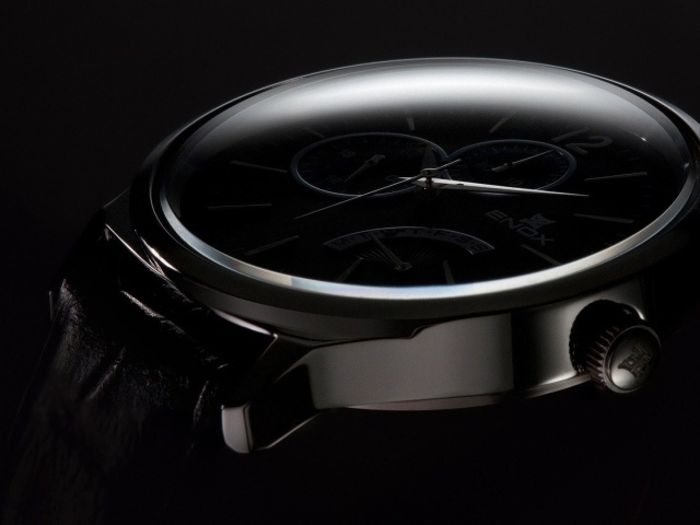 Дорогие черные часы на черном фоне