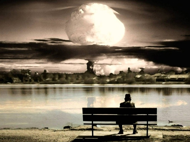 Человек смотрит на ядерный взрыв сидя на скамье