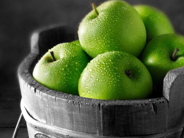 Ведро из дерева с зелеными яблоками