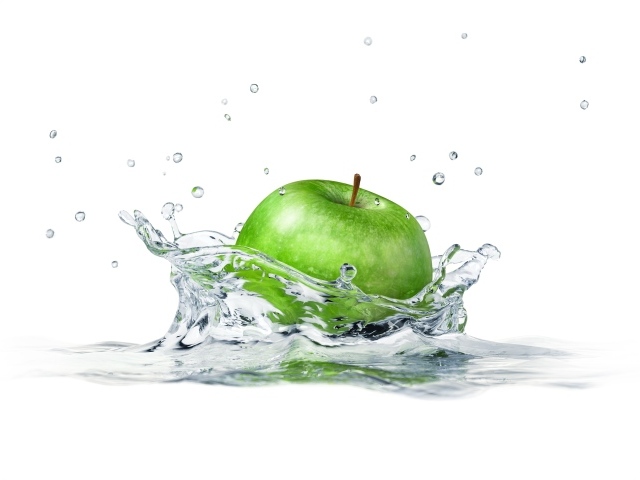 Зеленое яблоко падает в воду