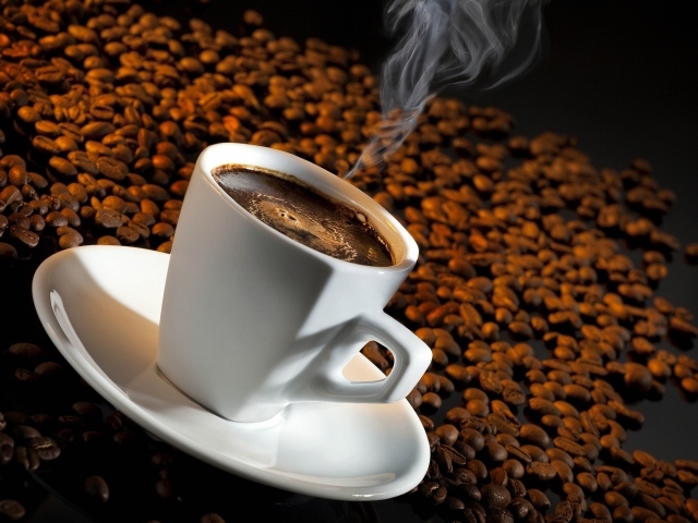 Белая чашка с кофе на зернах