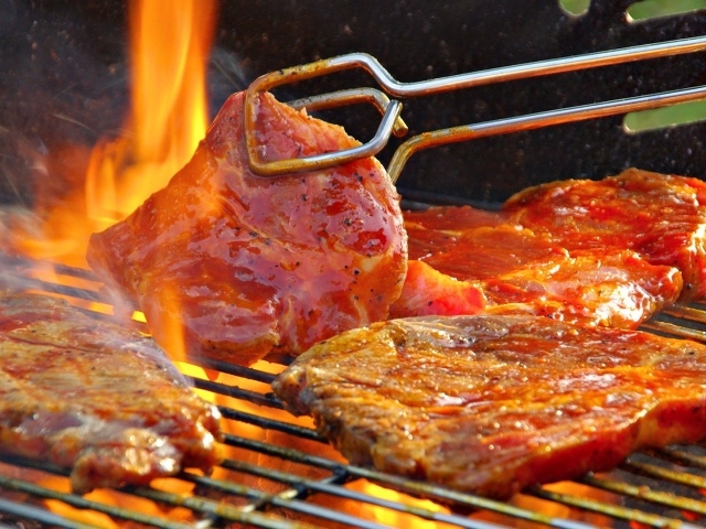 Стейк жарится на огне барбекю