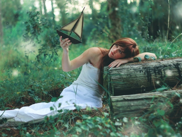 Девушка в белом платье держит в руке кораблик