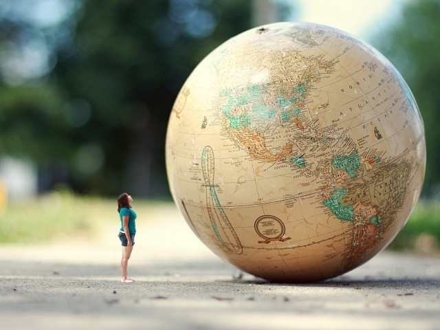 Девушка стоит перед огромным глобусом