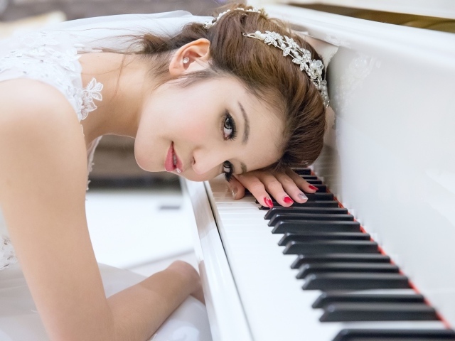 Азиатская девушка склонилась к белому пианино