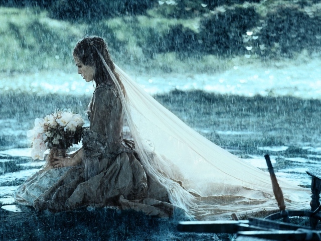 Невеста сидит на коленях под дождем