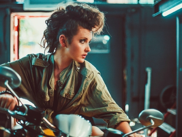 Брюнетка с высокой прической на мотоцикле