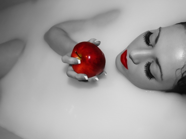 Девушка ест яблоко лежа в ванной