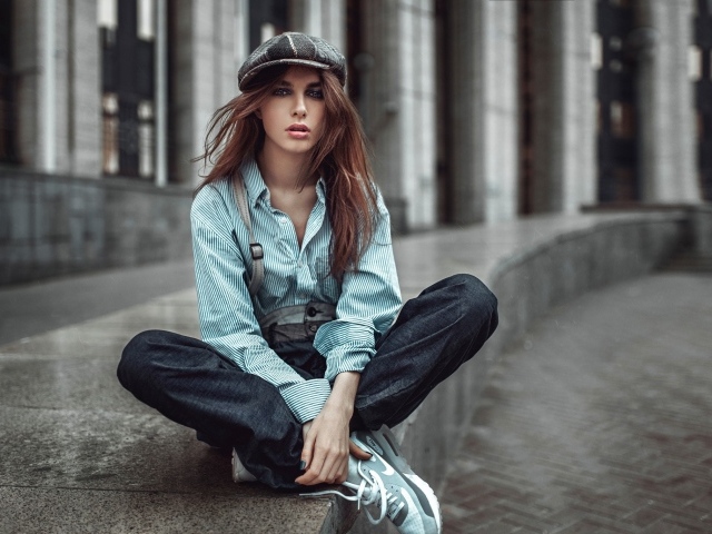 Девушка в берете сидит на краю дорожки