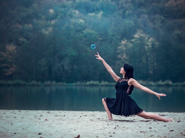 Девушка в черном платье и мыльный пузырь
