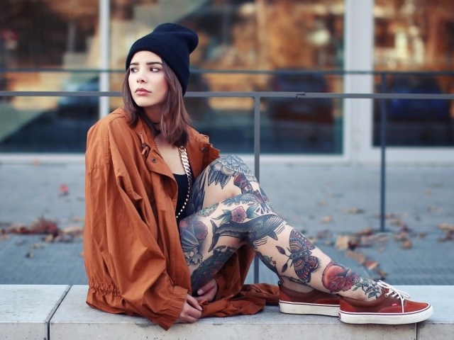 Девушка в шапке с тату на ногах