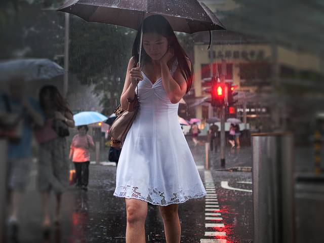 Девушка в белом платье идет под зонтом