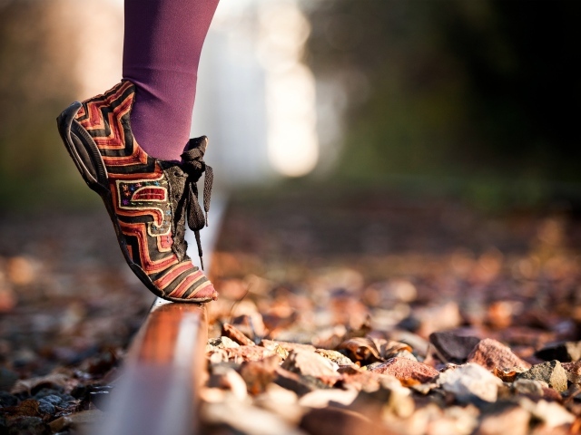 Девушка на носочках на рельсе