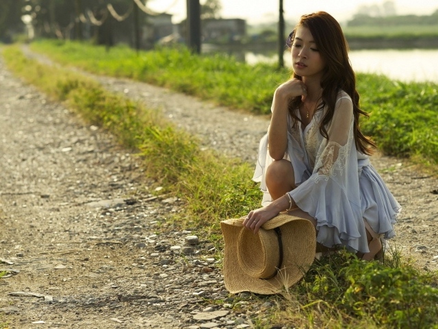 Девушка со шляпой присела на дорогу