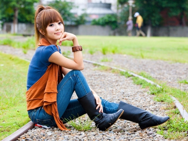 Японская девушка сидит на трамвайном пути