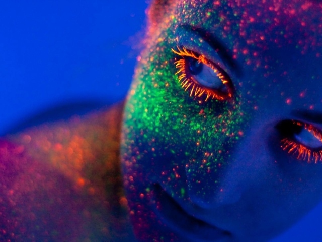 Неоновая краска на лице у девушки