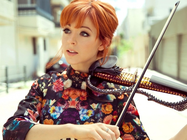 Рыжая девушка играет на скрипке со стразами