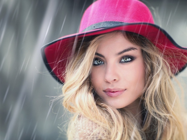 Блондинка в розовой шляпе под дождем