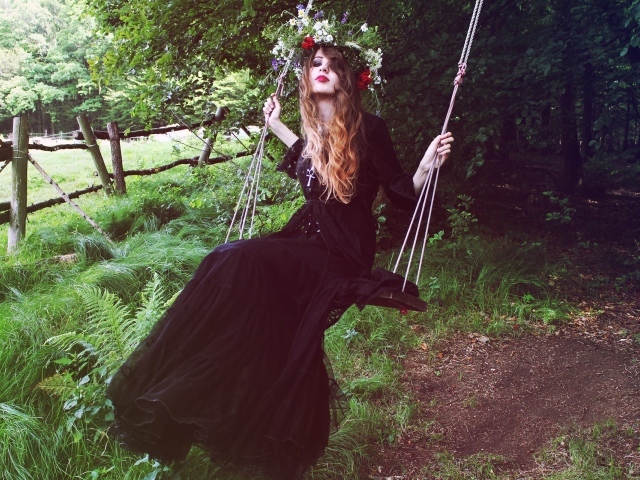 Девушка в черном платье на качели