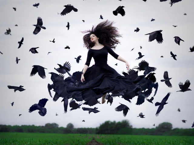 Девушка в черном платье парит среди ворон
