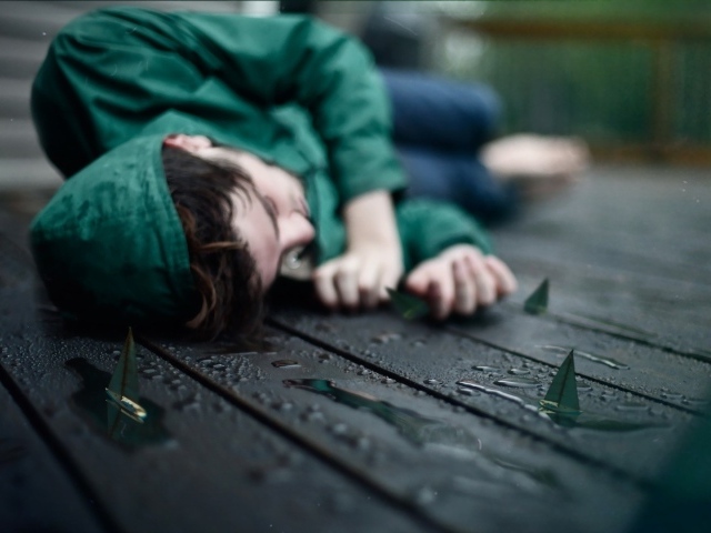 Девушка в зеленом лежит на мокрых досках