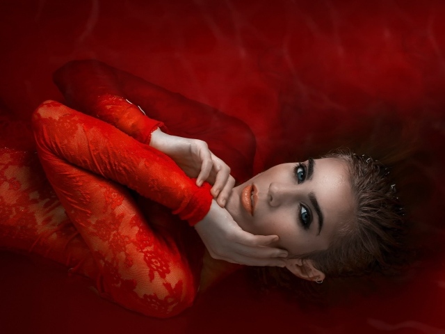 Девушка в красном кружевном платье на красном фоне