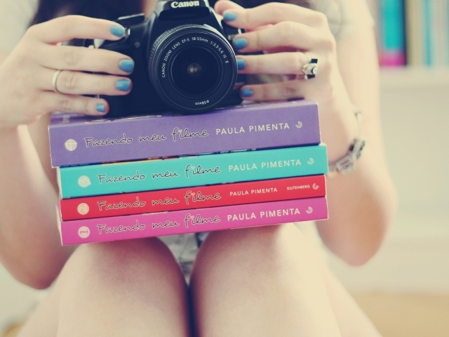 Девушка фотограф со стопкой книг