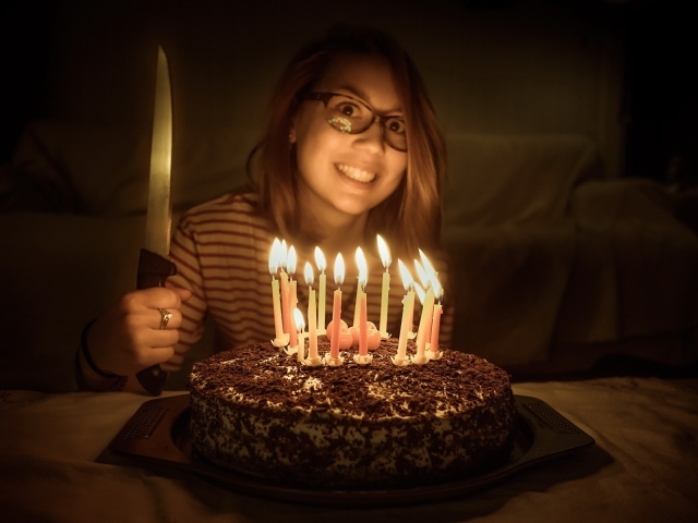 Девушка с ножом у праздничного торта