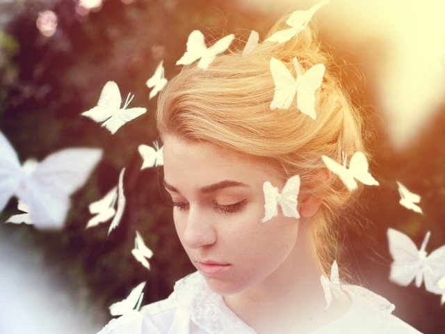 Белые бабочки летают вокруг девушки