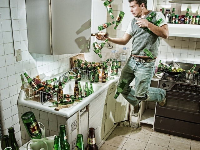 Мужчина среди бутылок пива на кухне