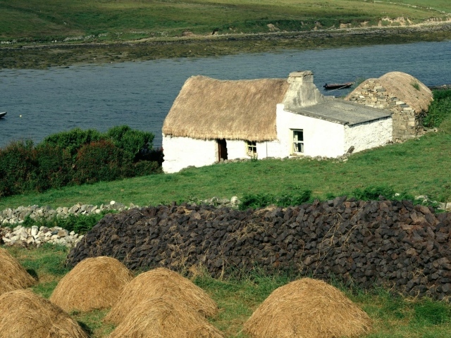 Покрытый соломой дом на берегу реки