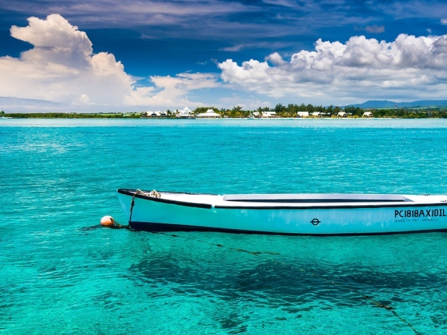 Белая лодка на голубой прозрачной воде