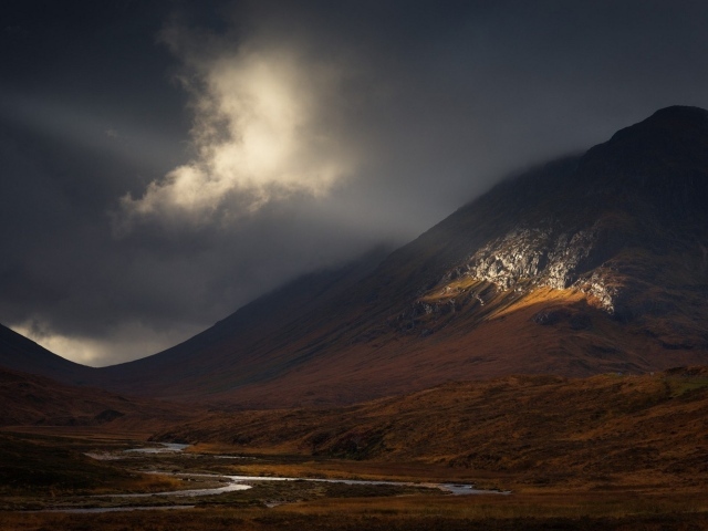 Луч солнца освещает часть склона горы
