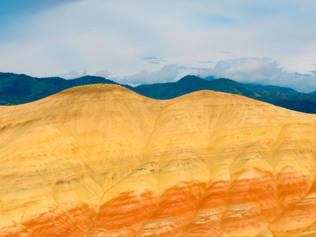 Голые скалы на фоне покрытых лесом гор