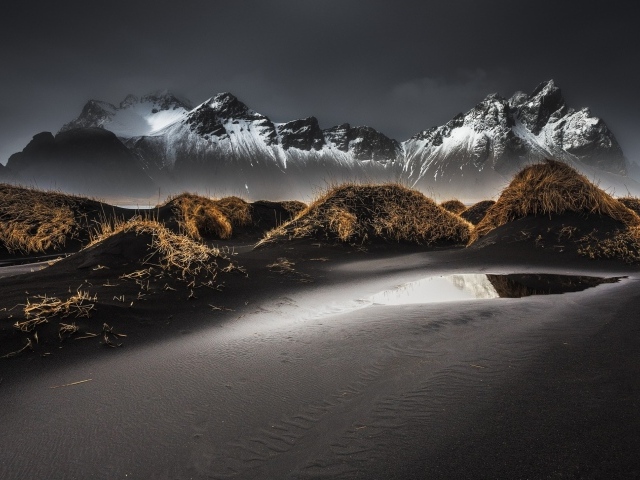 Серый песок на фоне гор