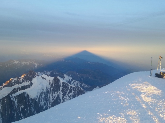 Лыжники на вершине горы перед закатом солнца