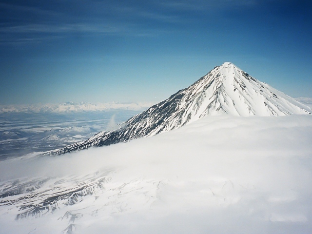 Вершина покрытой снегом горы в облаке
