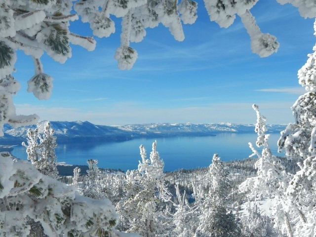 Горное озеро в рамке из заснеженных ветвей