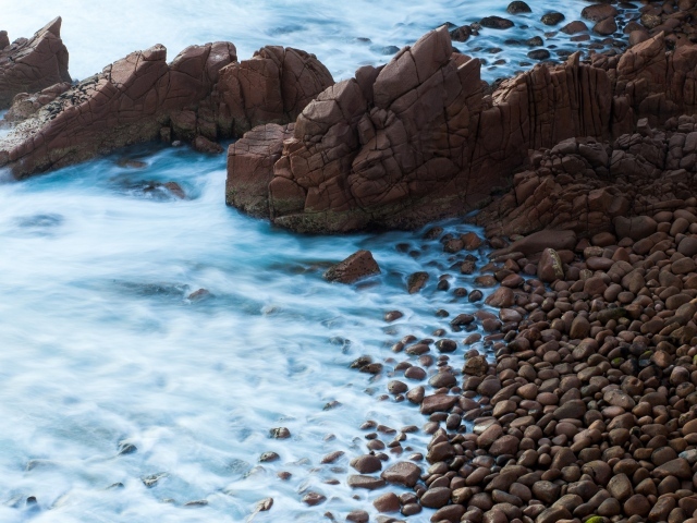 Мелкие коричневые камни на берегу моря