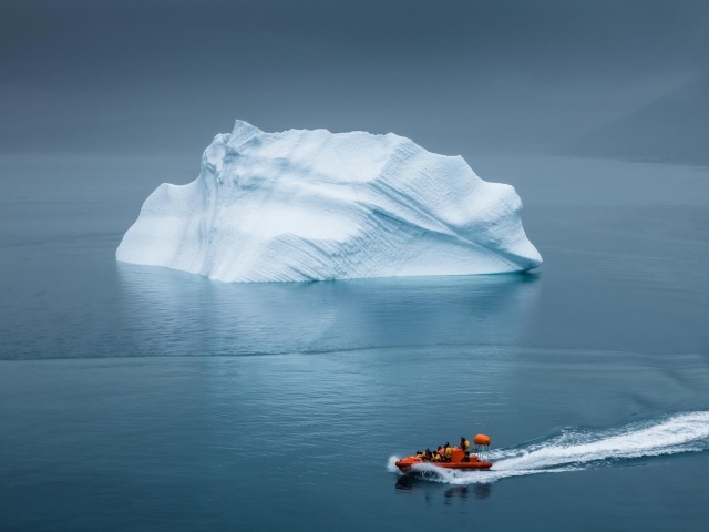 Моторная лодка у айсберга в Арктике